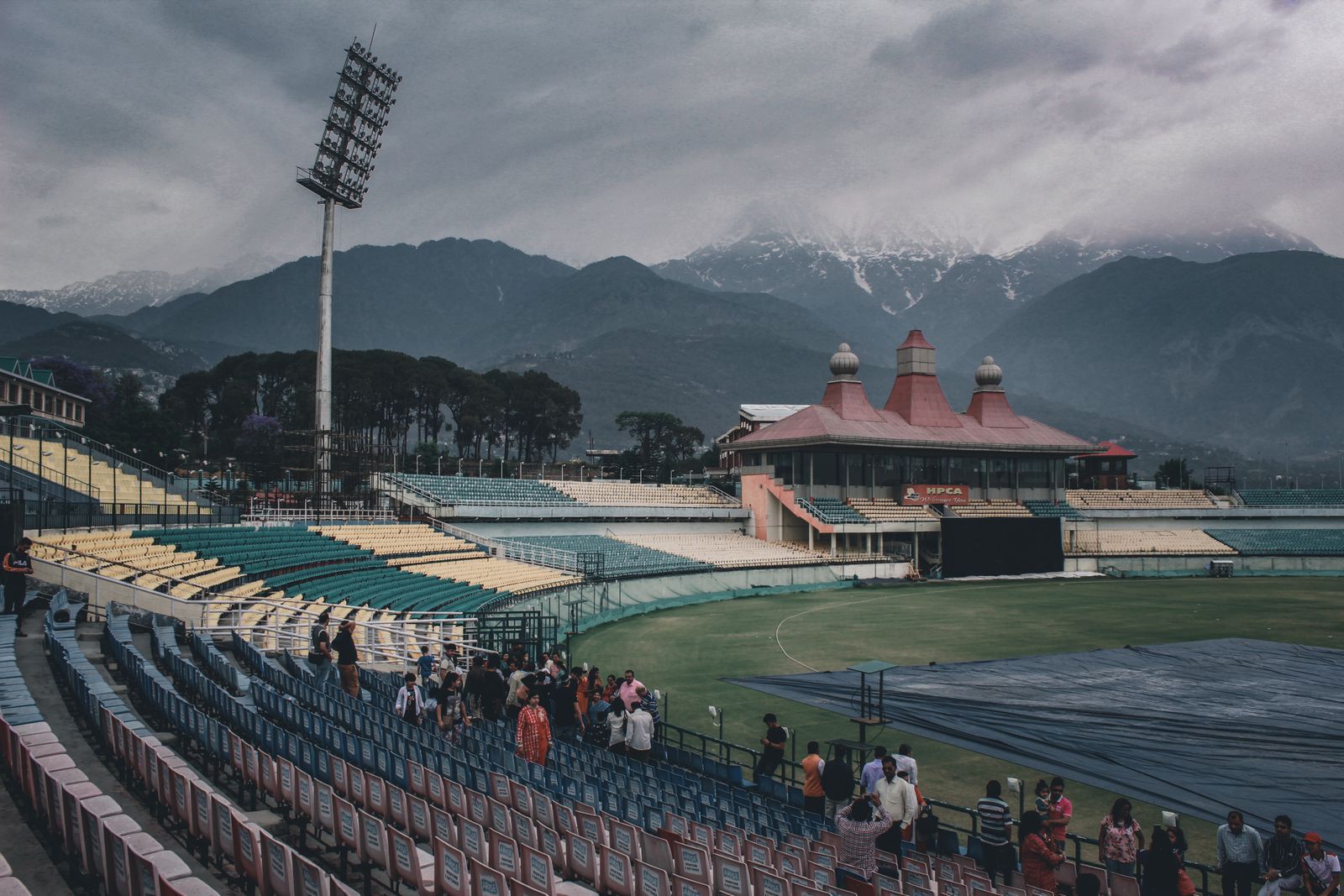Covers on a cricket ground under heavy cloud, as rain wiped out the Asian Games cricket quarter-finals