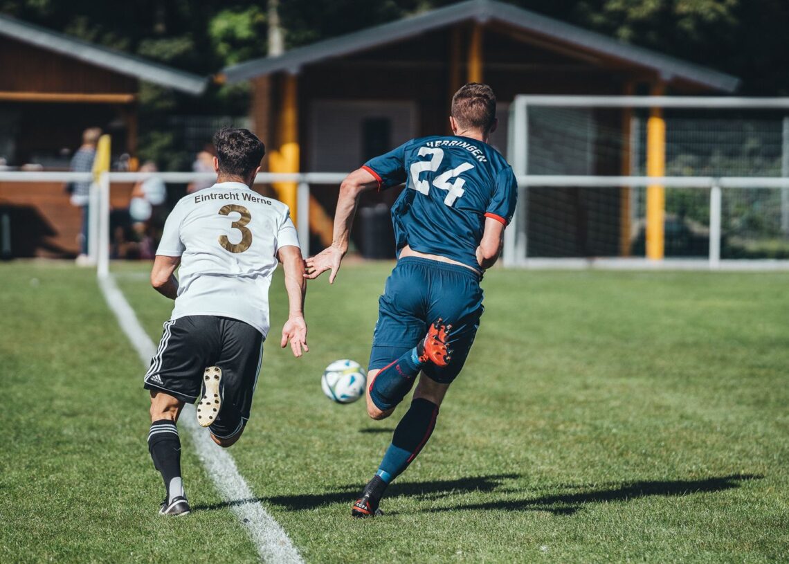Two footballers chasing the ball during a match (Pexels 6800039)