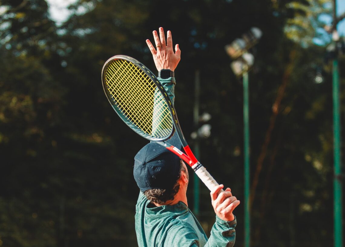 Tennis player tossing the ball to serve on an outdoor clay court (Pexels 38377267)