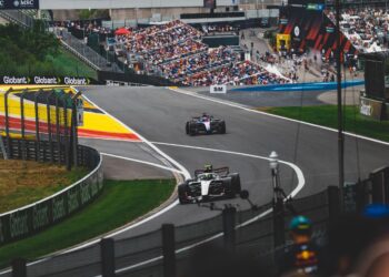 Formula 1 cars racing through a corner at Spa-Francorchamps in front of a packed crowd (Pexels 39520687)