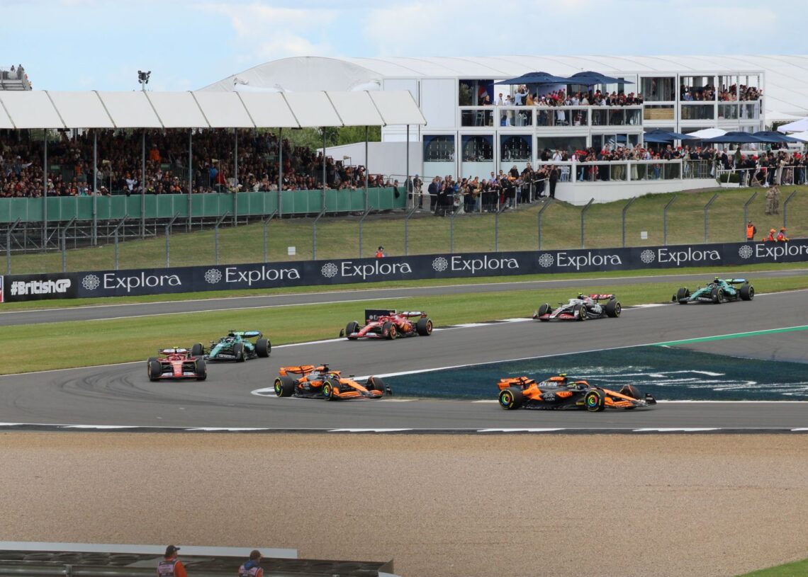 Formula 1 cars racing at Silverstone in front of packed grandstands (Pexels 36920241)
