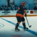 Ice hockey player skating with the puck in an indoor arena (Pexels 38555355)