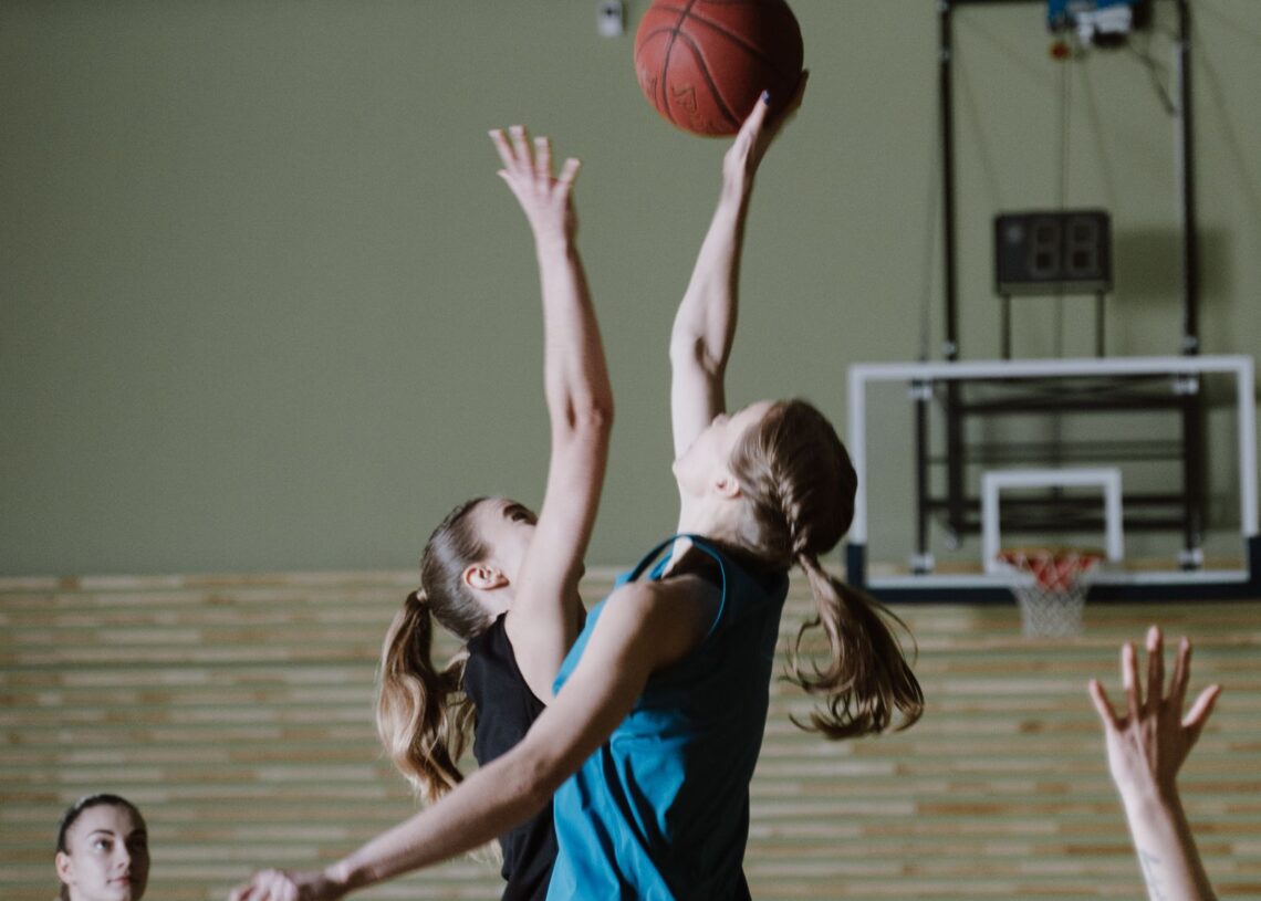 Lynx vs Fever: women basketball players contest a jump ball on an indoor court