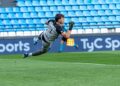 Slovenia vs Scotland: a goalkeeper dives to make a save in a Nations League-style match