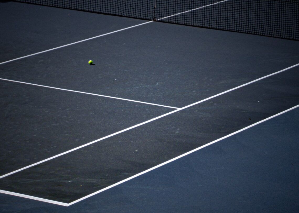 Tennis ball on a blue hard court