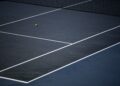 Tennis ball on a blue hard court